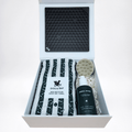 Dog grooming kit with towel, brush, lick mat and shampoo & conditioner in a box. Flat lay pamper pup hamper.