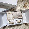 Sentimento Gifting Co. Gift set with a bottle, cap, and other items in an open box on a textured surface.